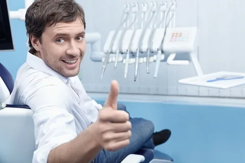 A patient showing a fearful expression while approaching a dental chair.