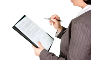 Official documents and forms arranged on a wooden desk surface.