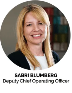 Headshot of Sabri Blumberg in professional attire.