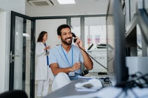 Young multiracial doctor sitting at the reception desk in a dental office.
