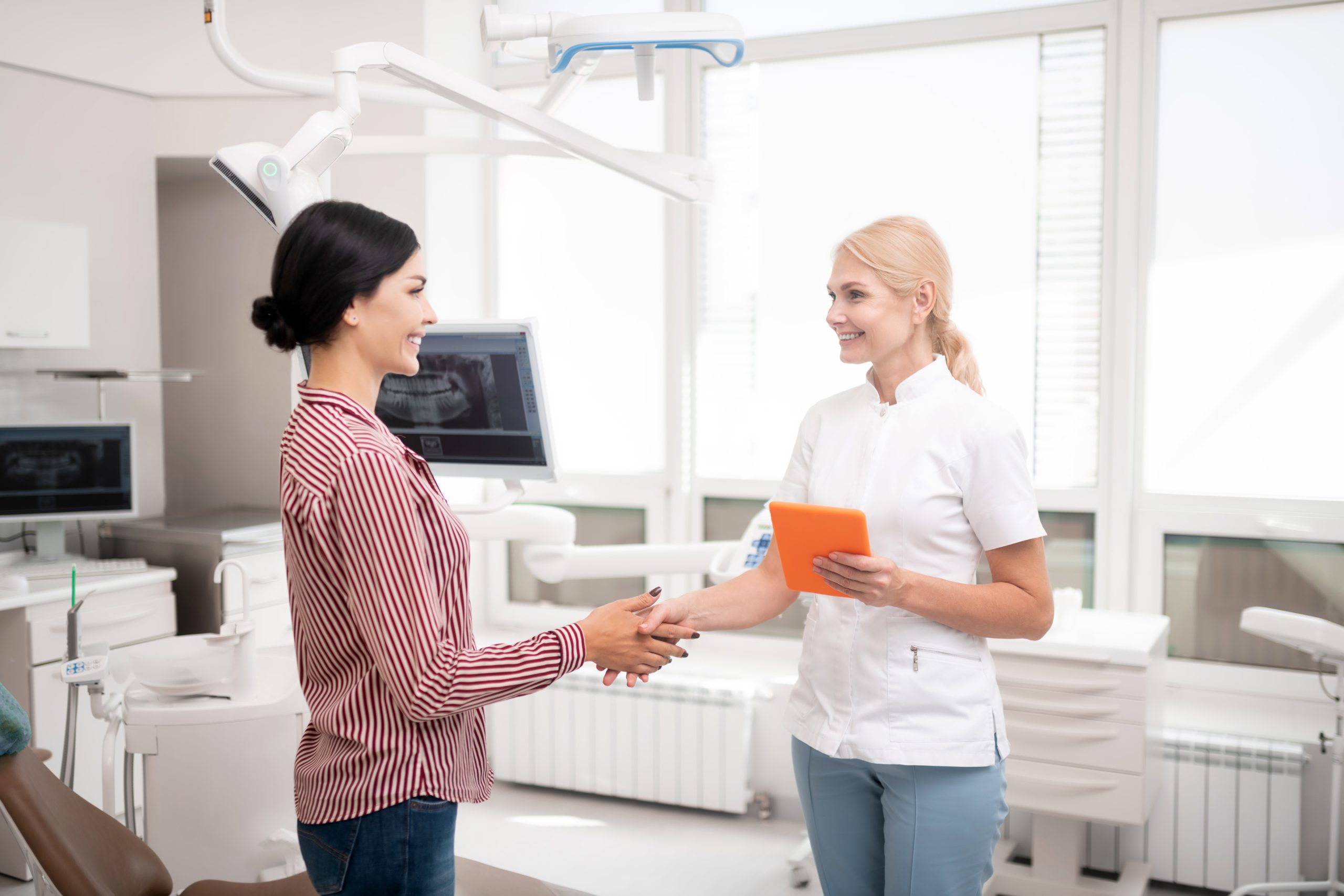 Exchanging Greetings Cheerful Dentist Shaking Hands With Her New Patient