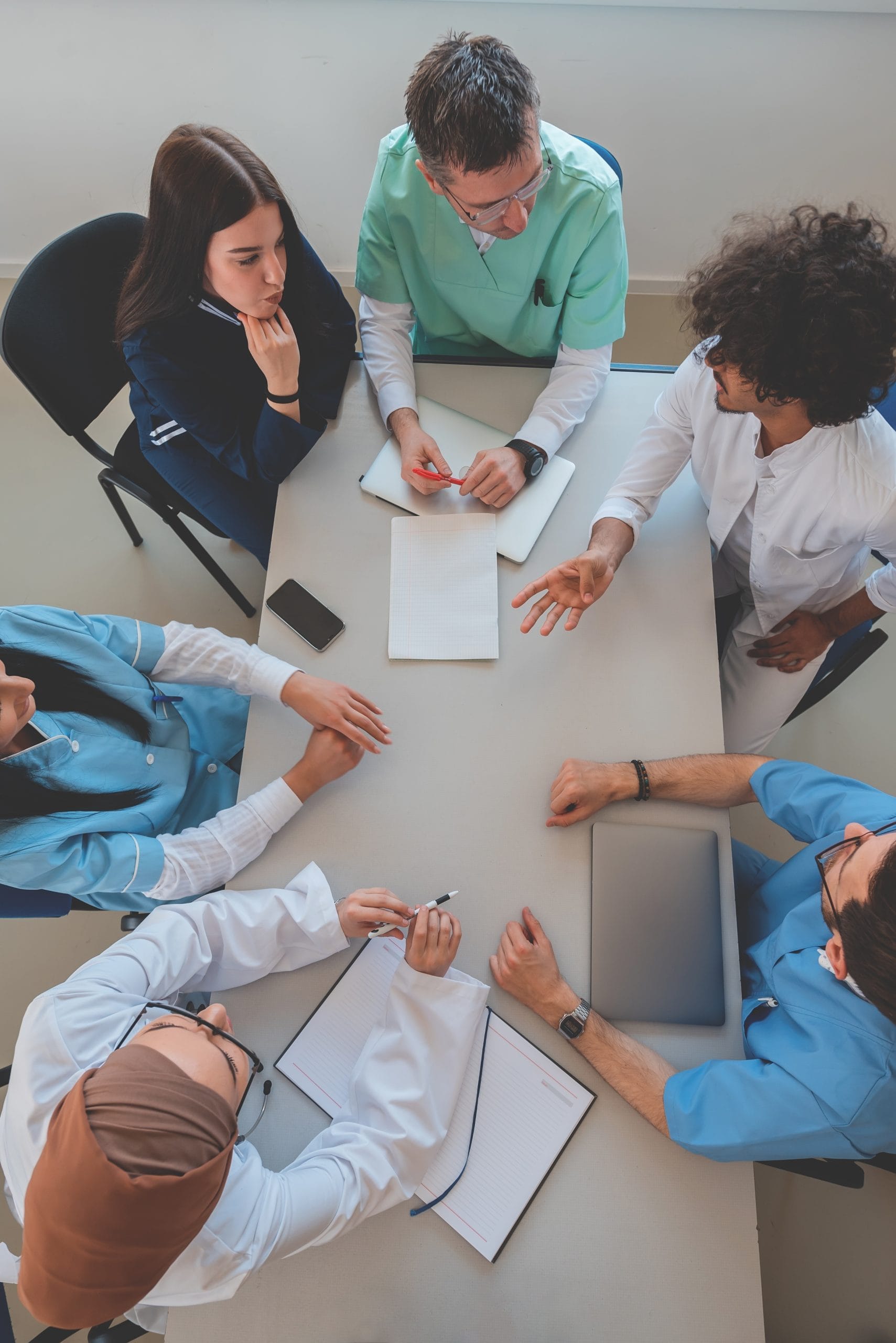 Ariel view of a table with people sitting around it, papers on the table. Staff meeting