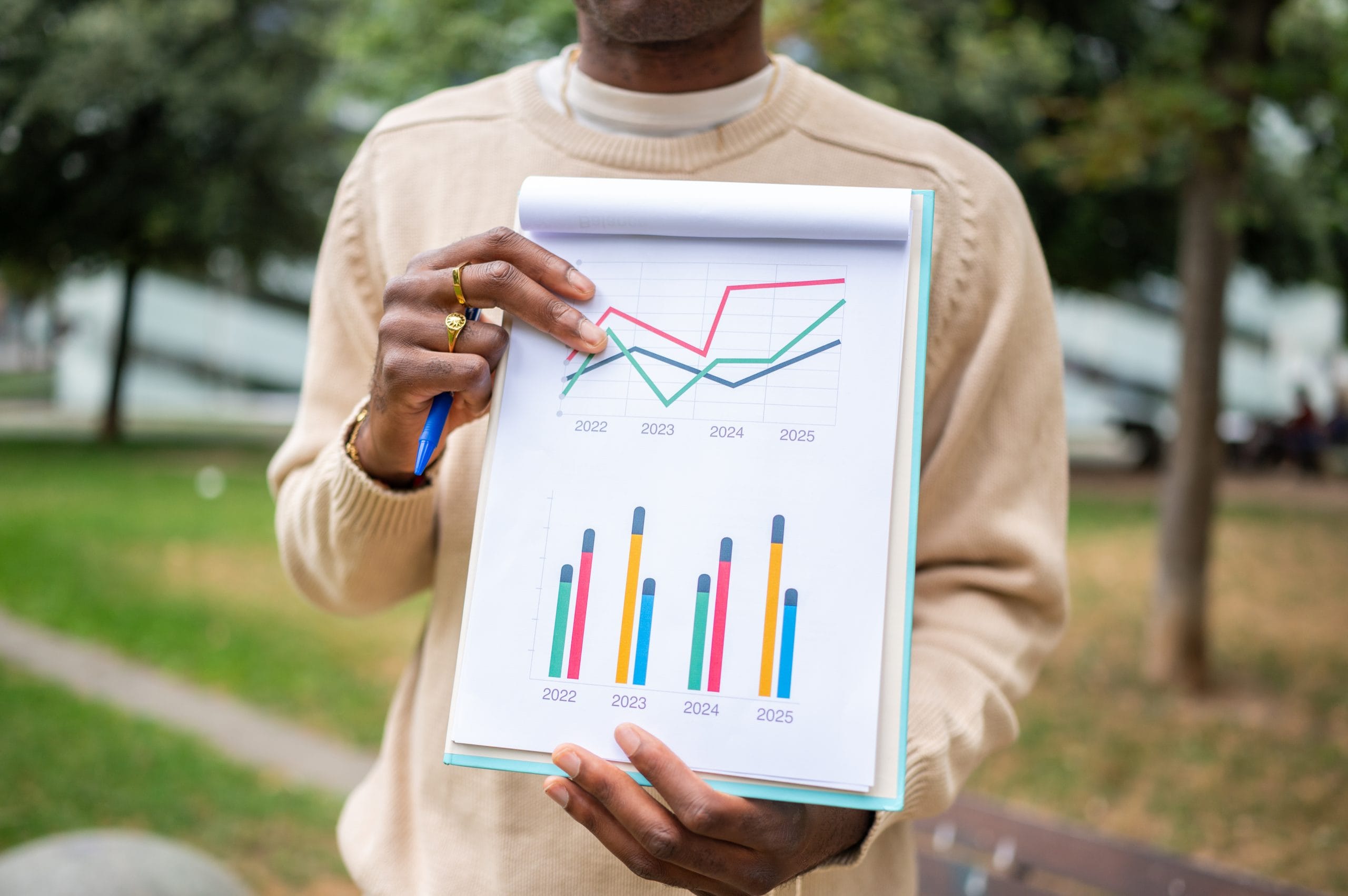 Hands holding a paper with statistics and column chart