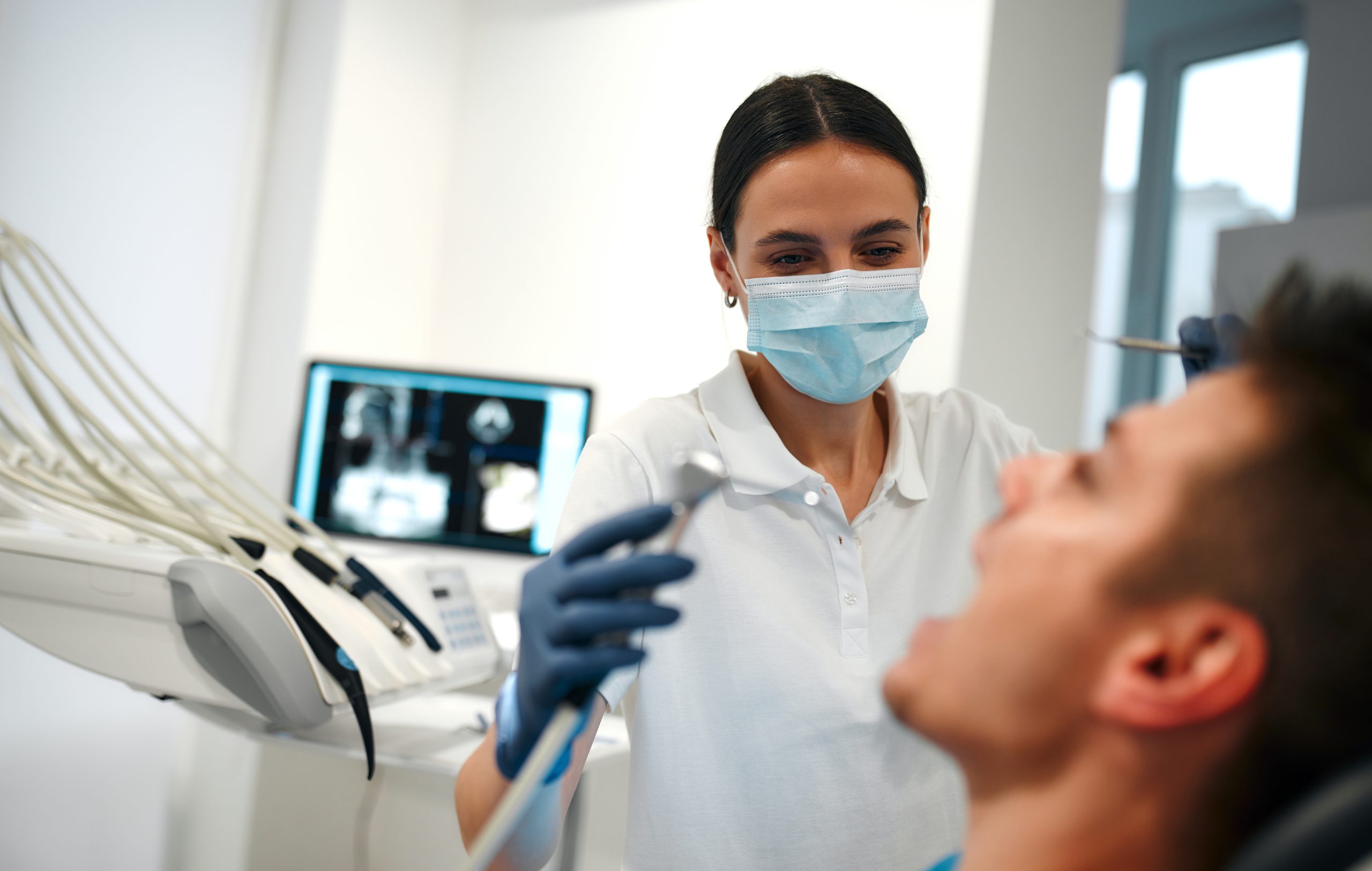 Female hygienist about to clean a patient's teeth.