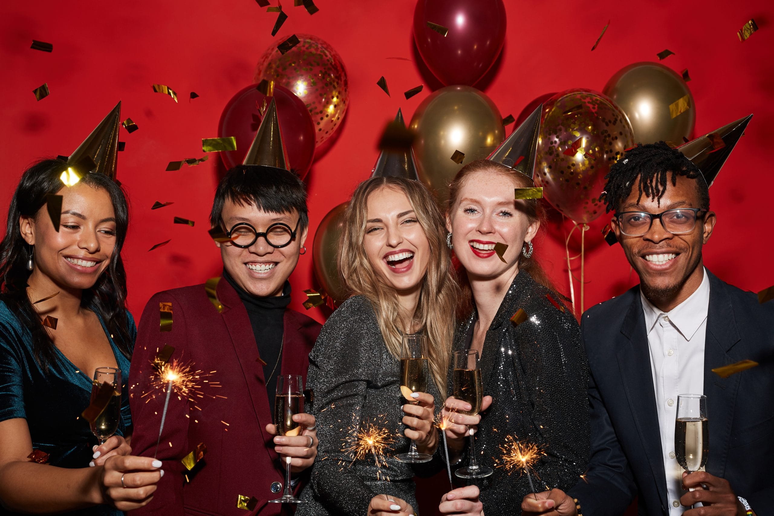 new year celebration with multiple people, balloons, streamers and confetti coming down