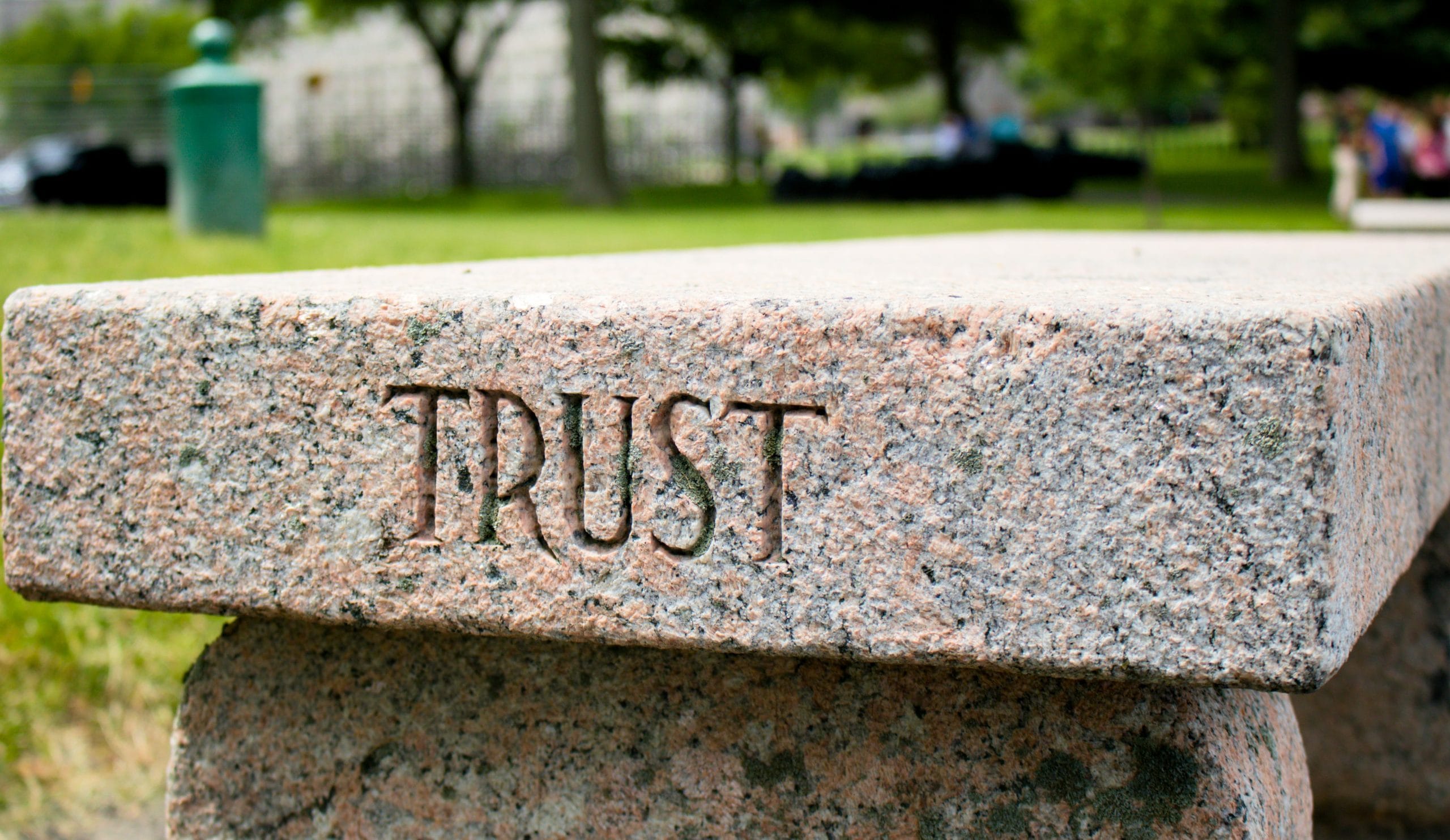 A stone bench with the word TRUST chiseled in.
